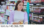 Young girl customer with tester, choosing perfume in cosmetic shop. Стоковое видео, видеограф Яков Филимонов / Фотобанк Лори
