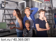 Brooding family tries to find a solution to a puzzle in a quest room. Стоковое фото, фотограф Яков Филимонов / Фотобанк Лори