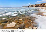 Baikal Lake on sunny May day. Melting ice on beach of Olkhon Island. Through thawed patches with clear water one can see stones at bottom of bay. Picturesque spring landscape. Spring hiking, travel. Стоковое фото, фотограф Виктория Катьянова / Фотобанк Лори