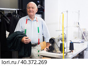 Portrait of an accomplished elderly tailor at his workplace in sewing workshop. Стоковое фото, фотограф Яков Филимонов / Фотобанк Лори