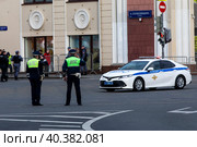 Инспекторы ДПС приветсвуют офицеров в автомобиле на посту на Таганской улице в центре города Москвы и обеспечивают безопасность движения на дороге, Россия (2023 год). Редакционное фото, фотограф Николай Винокуров / Фотобанк Лори