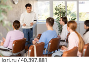 Positive student answering at lesson in front of groupmates. Стоковое фото, фотограф Яков Филимонов / Фотобанк Лори