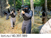 Impudent teams facing on battlefield in outdoor paintball arena during match. Стоковое фото, фотограф Яков Филимонов / Фотобанк Лори