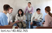 Exited adult students engaged in discussion sitting on chairs in circle in light room. Стоковое видео, видеограф Яков Филимонов / Фотобанк Лори