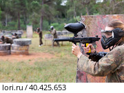 Paintball players of one team in camouflages and masks aiming with gun in shootout playing. Стоковое фото, фотограф Яков Филимонов / Фотобанк Лори