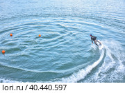 Motosurf Competitor taking corner at speed making a lot of spray. Jet surfing on a water, man riding on jet surfboard. Surfer in motion, summer sport. Стоковое фото, фотограф Олег Спиридонов / Фотобанк Лори