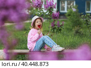 Lifestyle. A beautiful little girl in pink clothes with a lollipop in the shape of a heart. The girl licks the candy. The concept of love and sweets. Стоковое фото, фотограф Photojuli / Фотобанк Лори