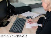 A female director working in an office is sitting at a table, analyzing business statistics, checking documents. Стоковое фото, фотограф Юрий Поздников / Фотобанк Лори