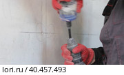 An electrician drills holes in the wall for sockets using a power tool. Close-up. Стоковое видео, видеограф Юрий Поздников / Фотобанк Лори