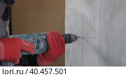 An electrician drills holes in the wall for sockets using a power tool. Close-up. Стоковое видео, видеограф Юрий Поздников / Фотобанк Лори