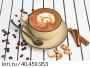 Cup of nut cappuccino with spoon and sugar on wooden white table side view. Стоковое фото, фотограф Татьяна Терехина / Фотобанк Лори