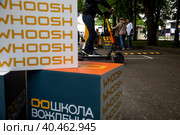 Люди учатся ездить на самокате на площадке обучения вождению электросамокатов сервиса аренды самокатов компании Whoosh в Парке Горького в центре города Москвы, Россия (2023 год). Редакционное фото, фотограф Николай Винокуров / Фотобанк Лори