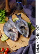 Raw peeled dorado fish with cooking ingredients. Fresh fish on a wooden background. Стоковое фото, фотограф Юрий Поздников / Фотобанк Лори