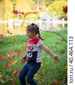 The girl throws colorful maple leaves for a walk in the park. Russia Moscow September 24, 2020. Редакционное фото, фотограф Юрий Поздников / Фотобанк Лори