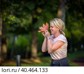 Girl laughs and plays with leaves in the park in summer Russia Moscow September 24, 2020. Редакционное фото, фотограф Юрий Поздников / Фотобанк Лори