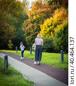 Mom rides a scooter with children in the park in summer (2020 год). Редакционное фото, фотограф Юрий Поздников / Фотобанк Лори