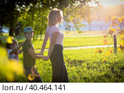Mom plays and dances with children in the park, laughs and spins with happiness. Russia Moscow September 24, 2020. Редакционное фото, фотограф Юрий Поздников / Фотобанк Лори