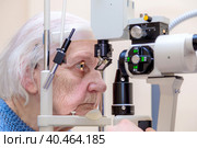 A male ophthalmologist checks the eyesight of an adult woman using a modern device with a light beam. Moscow Russia May 27, 2022. Редакционное фото, фотограф Юрий Поздников / Фотобанк Лори