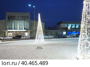 Petrozavodsk, Karelia, Russia, January 5, 2023. New Year's city fuss. Garlands - Christmas trees and lighting fixtures. Cars and people go through the snow. Karl Marx Avenue. National Finnish Theatre. Редакционное фото, фотограф Юлия Петровская / Фотобанк Лори