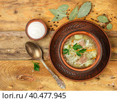 Sauerkraut soup is a traditional dish of Russian, Ukrainian or Polish cuisine. Kapustnyak. Soup with beef, potatoes, onions, cabbage, parsley and spices. Selective focus, top view. Стоковое фото, фотограф Виктория Панченко / Фотобанк Лори