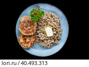 buckwheat with meat cutlets on a black background side view. Стоковое фото, фотограф Татьяна Терехина / Фотобанк Лори