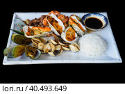 Sautéed seafood on white plate close up isolated on black background top view. Стоковое фото, фотограф Татьяна Терехина / Фотобанк Лори