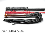 Black and red three bdsm whips on a white background close up. Стоковое фото, фотограф Артем Курутин / Фотобанк Лори