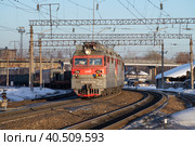 Электровоз ВЛ80С с грузовым поездом отправляются со станции солнечным мартовским вечером. Шарья, Костромская область (2022 год). Редакционное фото, фотограф Виктор Карасев / Фотобанк Лори