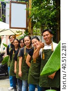Vietnamese coffee shop team smiling and standing together against a cafe. Стоковое фото, фотограф Татьяна Терехина / Фотобанк Лори
