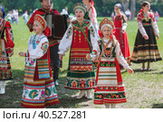 Russian folk traditions. Folk festivals. Children in beautiful Russian traditional outfits sing songs, dance and lead a round dance in Tsaritsyno Park. National Russian clothes. Sundresses and kokoshniks. (2023 год). Редакционное фото, фотограф Photojuli / Фотобанк Лори