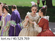 Reconstruction of the court ball of the mid-18th century of Her Imperial Majesty Catherine II in the Tsaritsyno Park in Moscow. Girls in ball gowns dance in the fresh air. (2023 год). Редакционное фото, фотограф Photojuli / Фотобанк Лори