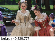 Reconstruction of the court ball of the mid-18th century of Her Imperial Majesty Catherine II in the Tsaritsyno Park in Moscow. Girls in ball gowns dance in the fresh air. (2023 год). Редакционное фото, фотограф Photojuli / Фотобанк Лори