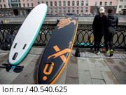 Участники заплыва костюмированной SUP-регаты в рамках фестиваля "Рыбная неделя" стоят на набережной Водоотводного канала в центре города Москвы, Россия (2023 год). Редакционное фото, фотограф Николай Винокуров / Фотобанк Лори