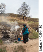 People of Caucasus. Old Dagestani (avar) lady. The hospitable hostess of an authentic cafe poses by the hearth where delicious tea is prepared. (2021 год). Редакционное фото, фотограф Саблин Станислав / Фотобанк Лори