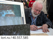 Художник-мультипликатор, режиссер Юрий Норштейн подписывает книги читателям на книжном фестивале "Красной площади" в центре города Москвы, Россия (2023 год). Редакционное фото, фотограф Николай Винокуров / Фотобанк Лори