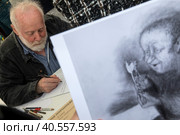 Художник-мультипликатор Юрий Норштейн подписывает книги читателям на книжном фестивале "Красной площади" в центре города Москвы, Россия (2023 год). Редакционное фото, фотограф Николай Винокуров / Фотобанк Лори