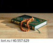 A green and gilded book of Quran and a rosary. Стоковое фото, фотограф Ирина Кононова / Фотобанк Лори