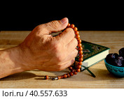 Hand of a senior Muslim man fingering a rosary. Стоковое фото, фотограф Ирина Кононова / Фотобанк Лори