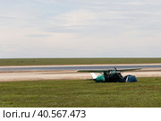 Россия, Калмыкия. 04.20.2019: Легкомоторный самолет Cessna 182 Skylane стоит в цветущей степи на берегу озера. Редакционное фото, фотограф Ольга Шуклина / Фотобанк Лори