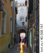 Herceg Novi, Montenegro, old town, Sat-kula tower, Sahat-kula, Tora, chapel tower or Clock tower 08.10.22 Tourists walk along the aisle under the city clock. Sunset, golden hour, summer evening. (2022 год). Редакционное фото, фотограф Юлия Петровская / Фотобанк Лори