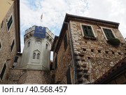 Herceg Novi, Montenegro, old town, Sat-kula tower, Sahat-kula, Tora, chapel tower or Clock tower 08.09.22 Tourists walk along the aisle under the city clock. Sunset, golden hour, summer evening. (2022 год). Редакционное фото, фотограф Юлия Петровская / Фотобанк Лори