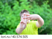 Boy shows sign gesture prison bars outdoors. Стоковое фото, фотограф Володина Ольга / Фотобанк Лори
