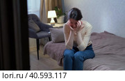 A sad Caucasian woman sits on the couch due to depression in the apartment. Стоковое видео, видеограф Денис Кебедов / Фотобанк Лори