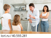At home in kitchen, outraged mom and dad scold their son and daughter for disobedience. Стоковое фото, фотограф Яков Филимонов / Фотобанк Лори