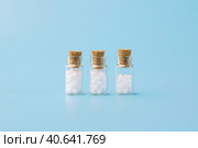 Homeopathic globules and glass bottle on blue background. Alternative Homeopathy medicine herbs, healtcare and pills. Стоковое фото, фотограф Tatiana Syrtseva / Фотобанк Лори