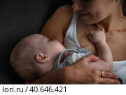 Adorable newborn baby sleeping on hands loving happy mother at home, closeup. Mommy with kid together in bedroom. Mom care 6 months old infant child. Concept of motherhood, maternity. Copy text space. Стоковое фото, фотограф Aleksandr Golubev / Фотобанк Лори