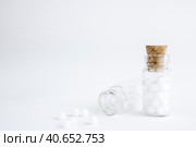 Homeopathic globules and glass bottle on white background. Alternative Homeopathy medicine herbs, healtcare and pills. Copy space . Стоковое фото, фотограф Tatiana Syrtseva / Фотобанк Лори