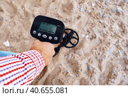 Male hand holding metal detector device above the ground. Стоковое фото, фотограф Сергей Толмачёв / Фотобанк Лори