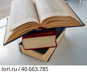A stack of three old books that lie on top of each other. The top book is open. Background for libraries, science, education. Стоковое фото, фотограф Бузмакова Светлана / Фотобанк Лори