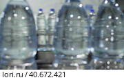 Синие пластиковые бутылки с водой движутся по конвейеру. Камера следует за бутылками. Завод по производству минеральной воды и безалкогольных напитков. Замедленное движение. Стоковое видео, видеограф Воловодов Владимир / Фотобанк Лори